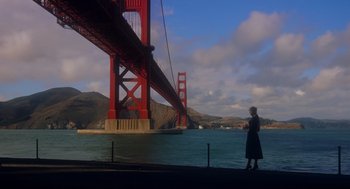 Movie still from “Vertigo” (1958), directed by Alfred Hitchcock – A woman standing in front of the golden gate bridge in san francisco; Extreme Wide shot, Low angle