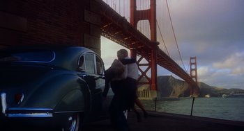 Movie still from “Vertigo” (1958), directed by Alfred Hitchcock – Two people are hugging in front of the golden gate bridge in san francisco; Wide shot, Low angle