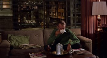 Movie still from “Vertigo” (1958), directed by Alfred Hitchcock – A man sitting at a table with a cup in his hand; Medium shot, High angle