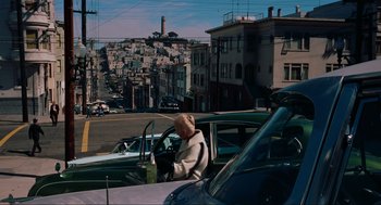 Movie still from “Vertigo” (1958), directed by Alfred Hitchcock – An older woman driving a car in the street; Extreme Wide shot, High angle
