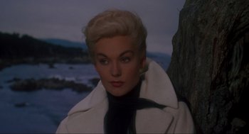 Movie still from “Vertigo” (1958), directed by Alfred Hitchcock – A woman with blonde hair wearing a white coat; Close Up shot, High angle