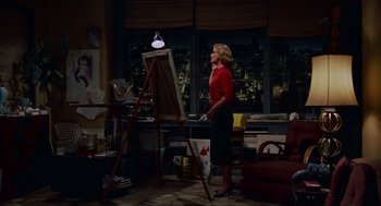 Movie still from “Vertigo” (1958), directed by Alfred Hitchcock – A woman standing in front of an easel in a room; Wide shot, High angle