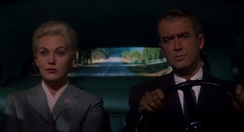 Movie still from “Vertigo” (1958), directed by Alfred Hitchcock – A man and a woman sitting in the back of a car; Medium shot, Low angle
