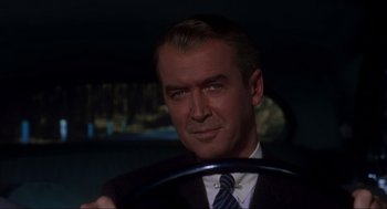 Movie still from “Vertigo” (1958), directed by Alfred Hitchcock – A person sitting in a car holding a steering wheel; Close Up shot, Over the shoulder angle