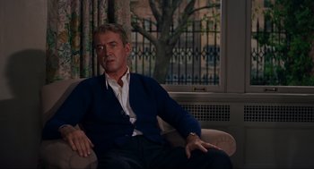 Movie still from “Vertigo” (1958), directed by Alfred Hitchcock – A man sitting in a chair in front of a window; Medium shot, Over the shoulder angle