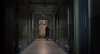 Movie still from “Vertigo” (1958), directed by Alfred Hitchcock – A woman is standing in a hallway looking out a window; Wide shot, High angle