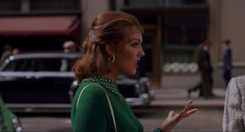 Movie still from “Vertigo” (1958), directed by Alfred Hitchcock – A woman in a green dress talking on a phone; Medium shot, Over the shoulder angle