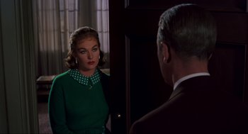 Movie still from “Vertigo” (1958), directed by Alfred Hitchcock – A woman in a green dress looking at a man in a brown suit; Medium shot, Over the shoulder angle