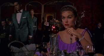 Movie still from “Vertigo” (1958), directed by Alfred Hitchcock – A woman sitting at a table with a candle in front of her face; Medium shot, Over the shoulder angle