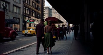 Movie still from “Vertigo” (1958), directed by Alfred Hitchcock – A group of people walking down the street under an umbrella; Wide shot, High angle