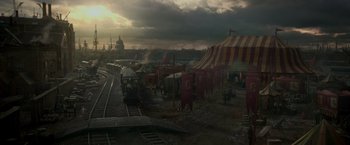 Movie still from “Victor Frankenstein” (2015), directed by Paul McGuigan – A train traveling down train tracks next to a train station; Extreme Wide shot, High angle