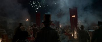 Movie still from “Victor Frankenstein” (2015), directed by Paul McGuigan – A man in a top hat and a crowd of people watching fireworks; Wide shot, Low angle