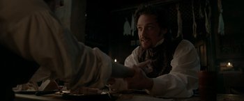 Movie still from “Victor Frankenstein” (2015), directed by Paul McGuigan – A man sitting at a table with a knife and fork; Close Up shot, Over the shoulder angle