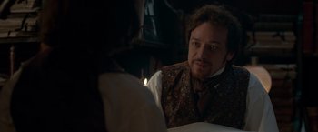 Movie still from “Victor Frankenstein” (2015), directed by Paul McGuigan – A man sitting in front of a candle in a room; Close Up shot, Over the shoulder angle