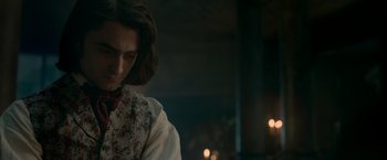Movie still from “Victor Frankenstein” (2015), directed by Paul McGuigan – A man with long brown hair wearing a white shirt; Close Up shot, Over the shoulder angle