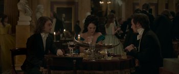 Movie still from “Victor Frankenstein” (2015), directed by Paul McGuigan – A woman sitting at a dinner table with a candle; Medium shot, High angle
