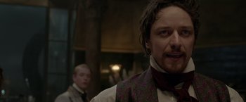 Movie still from “Victor Frankenstein” (2015), directed by Paul McGuigan – A person wearing a vest and a tie; Close Up shot, Over the shoulder angle