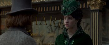 Movie still from “Victor Frankenstein” (2015), directed by Paul McGuigan – A woman wearing a green hat and a green jacket; Close Up shot, Over the shoulder angle