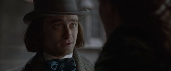 Movie still from “Victor Frankenstein” (2015), directed by Paul McGuigan – A person wearing a hat and a bow tie; Close Up shot, Over the shoulder angle