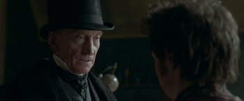 Movie still from “Victor Frankenstein” (2015), directed by Paul McGuigan – An older man wearing a top hat talking to a younger man; Close Up shot, Over the shoulder angle