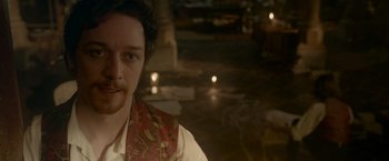 Movie still from “Victor Frankenstein” (2015), directed by Paul McGuigan – A young man in a red and gold vest; Close Up shot, Over the shoulder angle