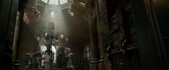 Movie still from “Victor Frankenstein” (2015), directed by Paul McGuigan – A person standing in a room with a lamp; Wide shot, Low angle