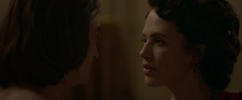 Movie still from “Victor Frankenstein” (2015), directed by Paul McGuigan – A woman looking at another woman's face in a dark room; Close Up shot, Over the shoulder angle