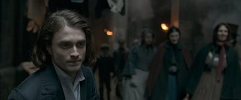 Movie still from “Victor Frankenstein” (2015), directed by Paul McGuigan – A man standing in front of a group of people; Close Up shot, Over the shoulder angle