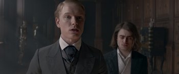 Movie still from “Victor Frankenstein” (2015), directed by Paul McGuigan – A man in a suit and tie next to another man in a suit and tie; Close Up shot, Over the shoulder angle