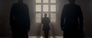 Movie still from “Victor Frankenstein” (2015), directed by Paul McGuigan – A person standing in front of a window in a room; Wide shot, Low angle