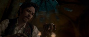 Movie still from “Victor Frankenstein” (2015), directed by Paul McGuigan – A man holding an umbrella and looking at his phone; Close Up shot, Low angle