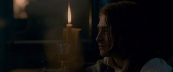 Movie still from “Victor Frankenstein” (2015), directed by Paul McGuigan – A man sitting in front of a lit candle; Close Up shot, Over the shoulder angle