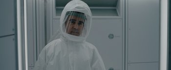 Movie still from “Voyagers” (2021), directed by Neil Burger – A man in a white lab coat wearing a face shield; Close Up shot, Over the shoulder angle