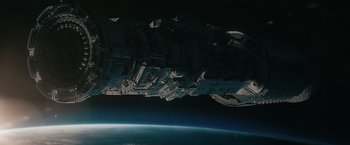 Movie still from “Voyagers” (2021), directed by Neil Burger – A view of a space ship from the space station; Extreme Wide shot, Overhead angle