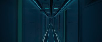 Movie still from “Voyagers” (2021), directed by Neil Burger – A long hallway with blue lights on either side of it; Extreme Wide shot, Overhead angle