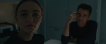 Movie still from “Voyagers” (2021), directed by Neil Burger – A woman sitting in front of another woman in a dark room; Close Up shot, Over the shoulder angle