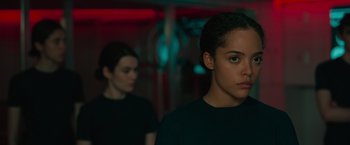 Movie still from “Voyagers” (2021), directed by Neil Burger – Two people in black shirts are standing in a room; Close Up shot, Over the shoulder angle
