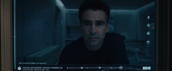 Movie still from “Voyagers” (2021), directed by Neil Burger – A man in black shirt sitting down in a room; Close Up shot, Overhead angle