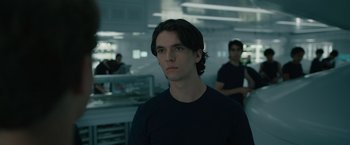Movie still from “Voyagers” (2021), directed by Neil Burger – A man in a black shirt is looking at the camera; Close Up shot, Low angle