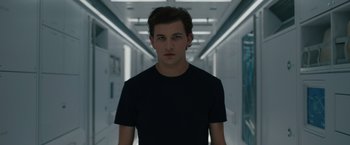 Movie still from “Voyagers” (2021), directed by Neil Burger – A man in a black shirt is standing in a hallway; Close Up shot, Low angle