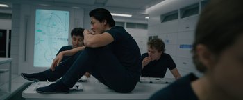 Movie still from “Voyagers” (2021), directed by Neil Burger – A group of young men sitting on top of a table; Medium shot, Low angle