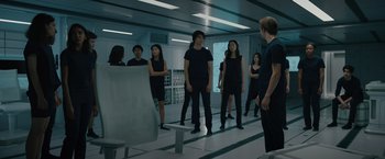 Movie still from “Voyagers” (2021), directed by Neil Burger – A group of people standing in a room; Wide shot, High angle