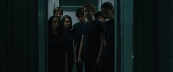 Movie still from “Voyagers” (2021), directed by Neil Burger – A group of young people standing in a hallway; Medium shot, High angle