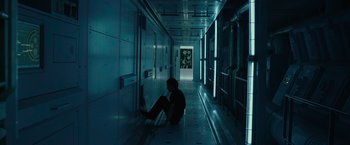 Movie still from “Voyagers” (2021), directed by Neil Burger – A man sitting on the floor of a hallway; Wide shot, High angle