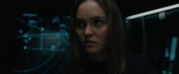 Movie still from “Voyagers” (2021), directed by Neil Burger – A woman with long brown hair stares into the camera; Close Up shot, Over the shoulder angle