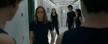 Movie still from “Voyagers” (2021), directed by Neil Burger – A group of young people walking down a hall way; Medium shot, Over the shoulder angle