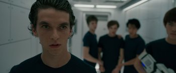 Movie still from “Voyagers” (2021), directed by Neil Burger – Three young men standing next to each other in a hallway; Close Up shot, Over the shoulder angle