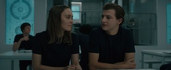 Movie still from “Voyagers” (2021), directed by Neil Burger – A man and a woman sitting next to each other; Medium shot, Over the shoulder angle