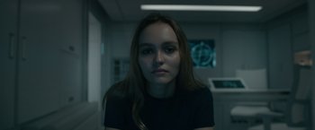 Movie still from “Voyagers” (2021), directed by Neil Burger – A woman with long brown hair wearing a black t - shirt; Close Up shot, Low angle