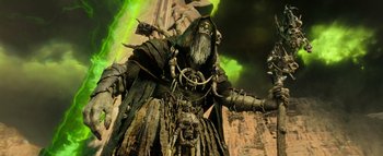 Movie still from “Warcraft” (2016), directed by Duncan Jones – An image of an old man with long hair and a long beard standing in front of a building; Medium shot, Low angle
